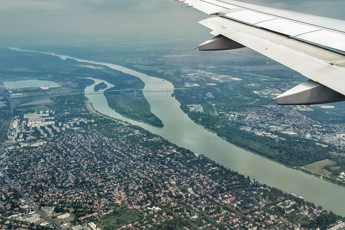 The wing of an airplane is visible, with Hungary and the Danube River down below.